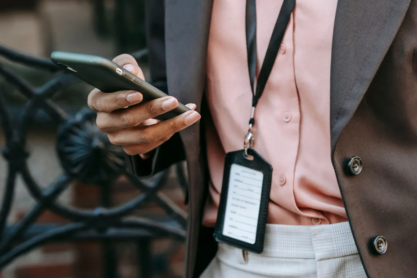A person wearing a lanyard, using a phone