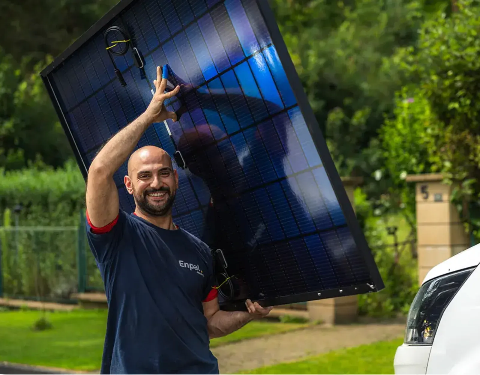 An Enpal team member carrying a solar panel